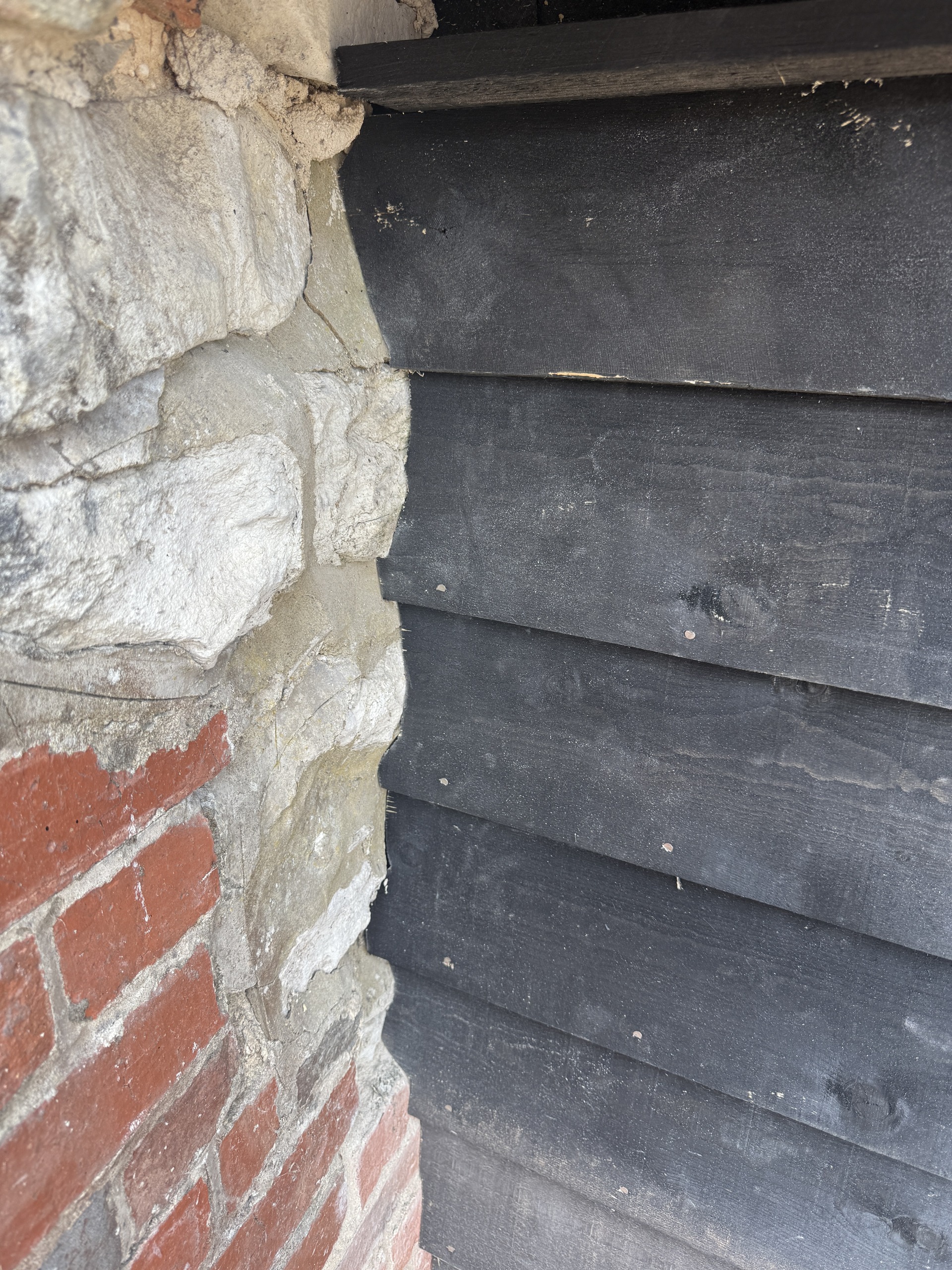 Timber cladding scribed to meet irregular stonework
